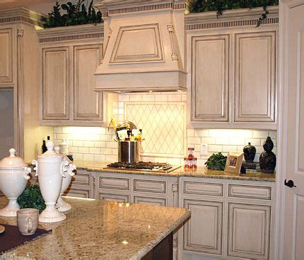 We inherited black granite counter tops and painted white cabinets from the previous owners, so we. Cream colored distressed kitchen cabinets with dark ...