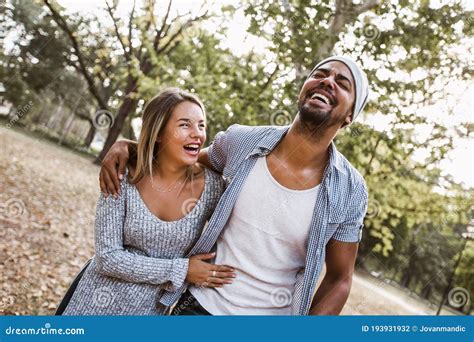 Portrait Of Romantic And Happy Mixed Race Young Couple In Park Stock