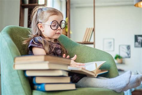 Little Toddler Girl In Glasses Reading A Book Back To School Concept
