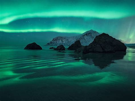 The Northern Lights Glow Over Skagsanden Beach In Norways Remote