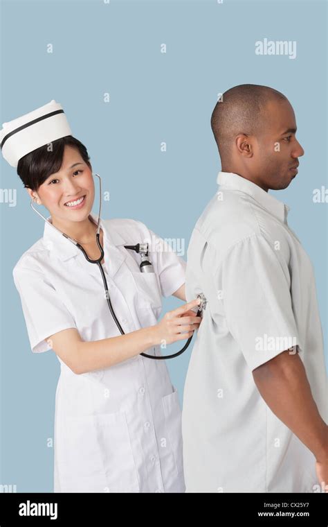Portrait Of A Happy Female Doctor Examining Male Patients Back With