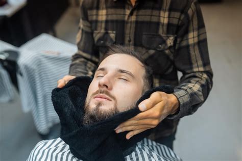free photo barber preparing man face for shaving with hot towel on face in barber shop