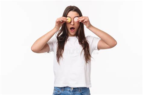 Portrait Of Amused Excited Young Cute Girl In White T Shirt Holding Tasty Two Macarons Over