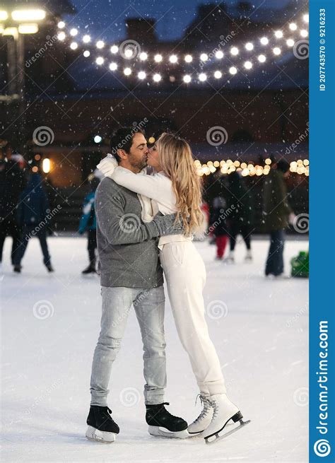 Happy Couple Of Lovers Having Fun Hugging An Kissing At Ice Skating