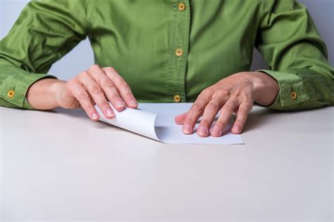 Premium Photo Hands Folding A Sheet Of Paper