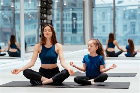 Madre Adulta Joven Y Pequeña Hija Juntas Practicando Yoga Foto Gratis