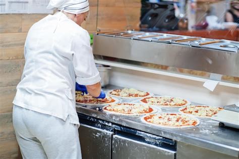 Premium Photo Female Chef Preparing Pizza In Restaurant Kitchen