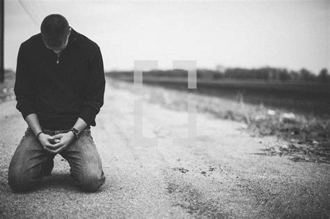Man Kneeling In Prayer In The Middle Of A Rural — Photo — Lightstock