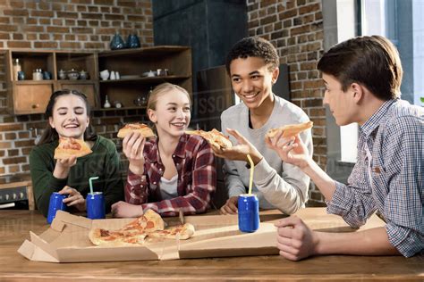 Happy Friends Spending Time Together With Pizza And Soda Drinks Eating
