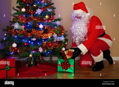 Foto De Santas Claus Entregando Regalos Y Poner Los Regalos Bajo El árbol De Navidad Fotografía
