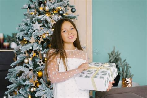 Excited Curious Little Girl Smiles As She Opens Christmas T