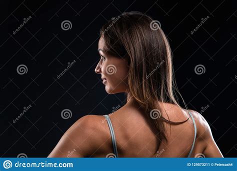 Attractive Fitness Woman Is Standing Back And Looking To The Side Stock