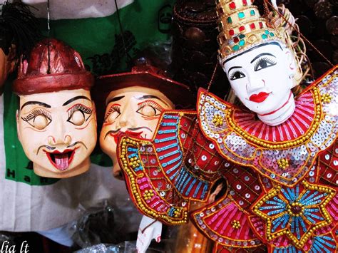 Two Masks With Faces Painted On Them Are Displayed In Front Of Other