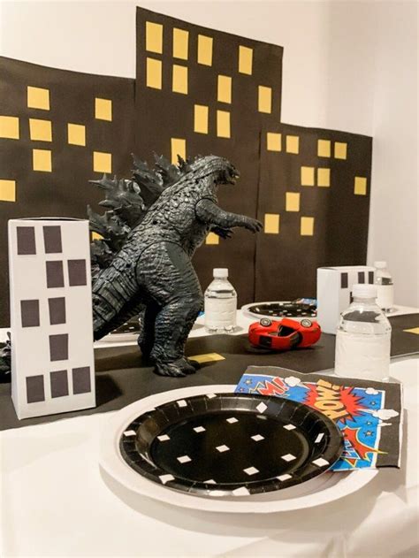 A Table Topped With Plates And Godzilla Figurines