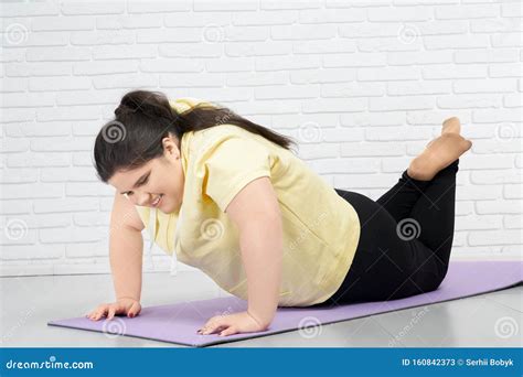 Brunette Fat Girl Is Trying To Do Push Ups In Mat Indoors Stock Image