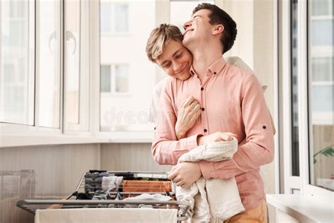 Man Bonding His Boyfriend With Tenderness While Hanging Up The Laundry