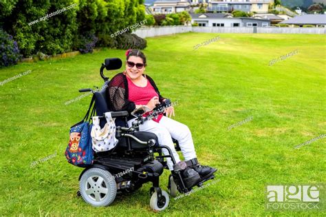 Maori Woman With Cerebral Palsy In A Wheelchair On A Grass Field In A
