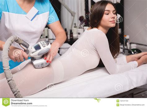 Female Having Procedure Of Massage On Legs In Apparatus Cosmetology Clinic Woman In Special