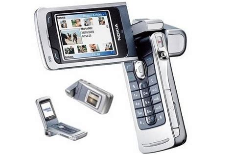 an open flip phone with two cell phones next to it and another device in the foreground