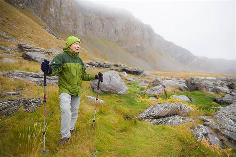 A Woman Hikes The Rocky Coast Of Vaeroy Island Lofoten Islands Norway