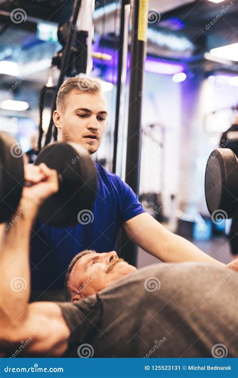 Personal Trainer Instructing Older Man During Exercise Stock Image