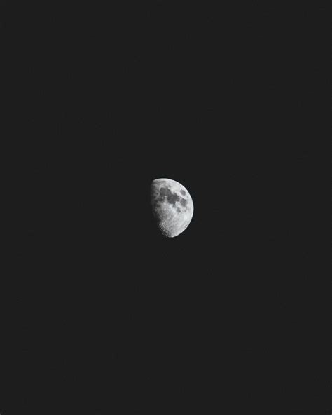 Dark Spots Visible On A Half Moon Against A Black Night Sky Beyond 4k