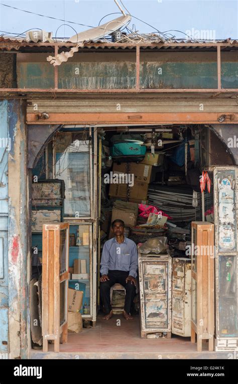 An Old Shop Keeper Sits On A Stool Inside His Store On Mg Road Panjim
