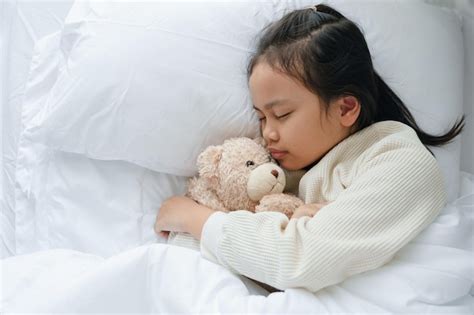 Premium Photo Asian Little Girl Sleeping And Hug Teddy Bear In The
