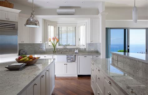 Set atop white cabinets with warm cream walls and backsplash, the soft pattern of muted hues of the countertop adds the perfect amount of detail to an otherwise mostly monochromatic kitchen. Add Luxury to Your Kitchen with River White Granite Countertop - HomesFeed