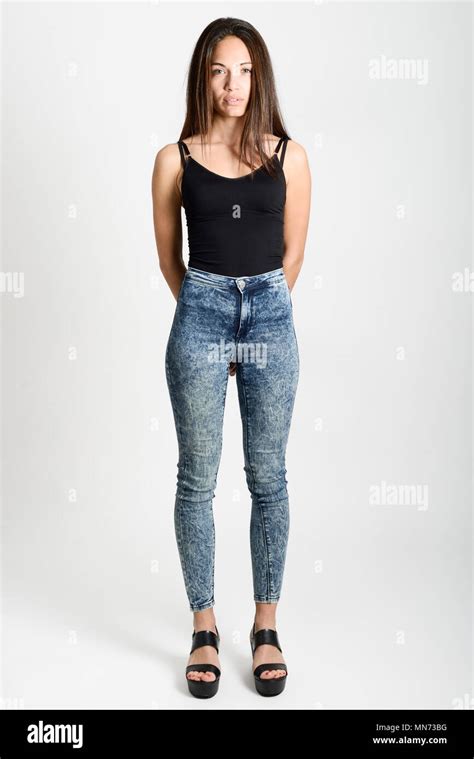 Young Woman Wearing Black Tank Top And Blue Jeans On White Background