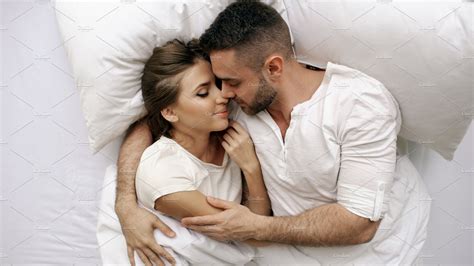 Young Beautiful And Loving Couple Kiss And Hug Into Bed While Waking Up
