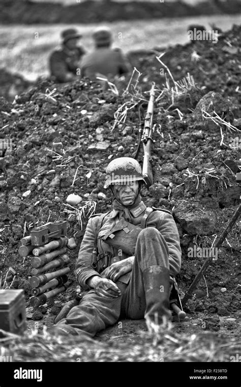 World War 11 Soldier Sitting In The Trenches On A Battlefield Stock