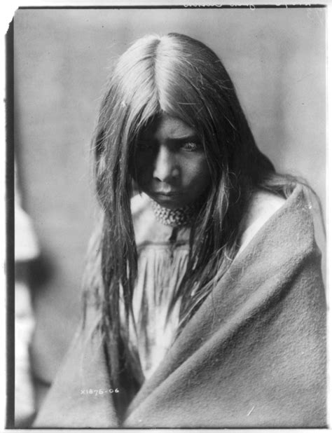 Zosh Clishn Apache Looking Down Wrapped In A Blanket And Wearing Several Necklaces
