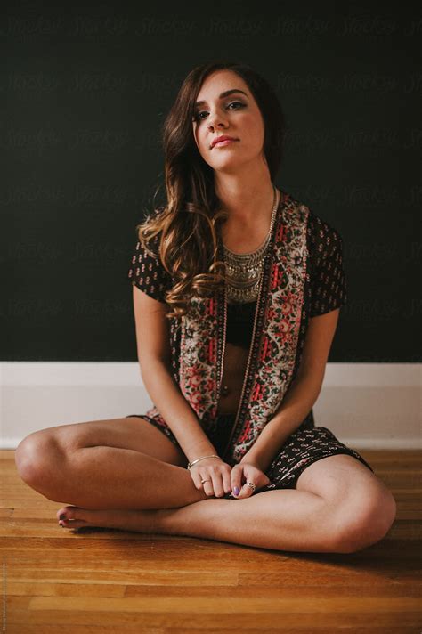 Young Attractive Bohemian Model Sitting Cross Legged On Old Wood Floor