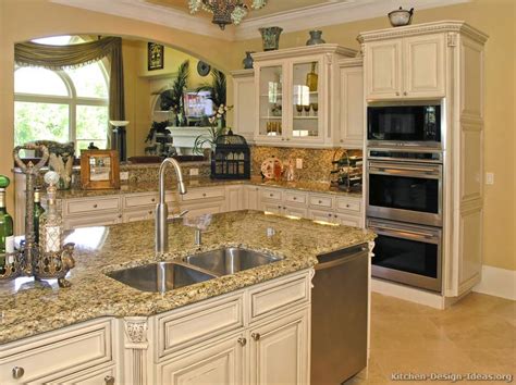 The kitchen island serves as centerpiece with its beige granite countertop and dark warm wood paneled plinth and base. Pictures of Kitchens - Traditional - Off-White Antique Kitchen Cabinets