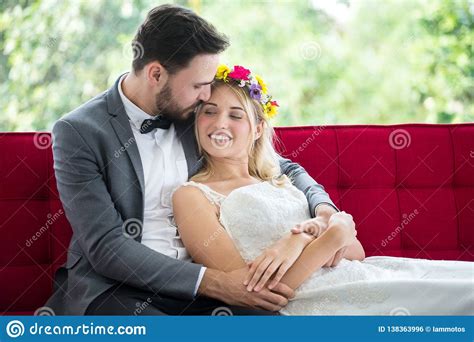 Young Couple In Love Wedding Bride And Groom Lying Down On Red Sofa