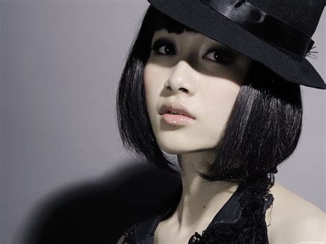 Portrait of young asian woman with beautiful and healthy dark hair looking at camera isolated on black. asian women face black hair funny hats short hair pale ...