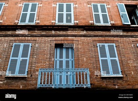 Red Brick House With Blue Balcony And Closed Shutters Toulouse France