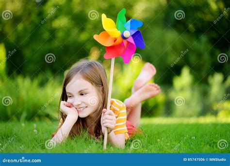 Adorable Little Girl Holding Colorful Toy Pinwheel On Summer Day Stock