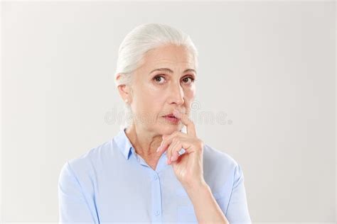 Portrait Of Elegant Mature Woman With Finger On Her Lips Looking At