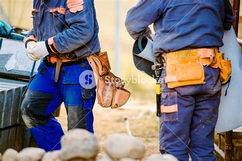Close Up Of Two Construction Workers With Tool Bags On Site Royalty