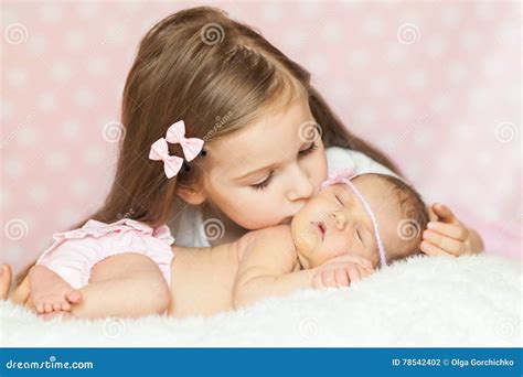 Niña Linda Que Besa A Su Hermana Recién Nacida Durmiente Foto De