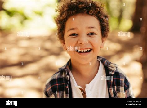 Close Up Portrait Of Cute Boy Smiling Outdoors Kid Looking At Camera