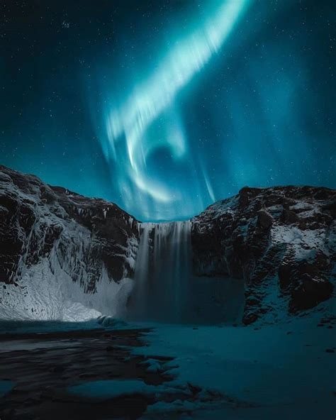 The Northern Lights Dancing In The Sky Of Iceland Above The Skógafoss