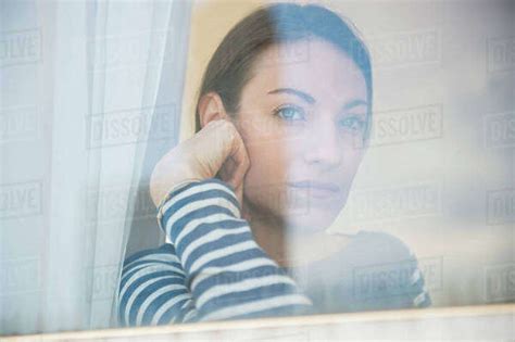 Woman Looking Through Window Stock Photo Dissolve