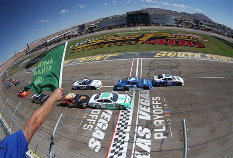 A Person Pointing To The Side Of A Race Track With Cars On It And