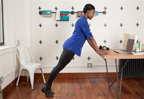 A Woman In Blue Shirt Doing Exercises At Desk