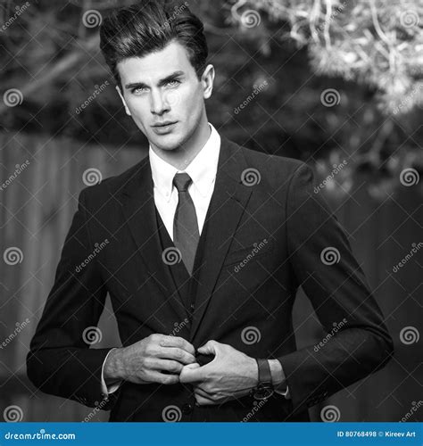 Black White Outdoor Portrait Of Elegant Handsome Man In Classical Suit Near Wooden Fence Stock