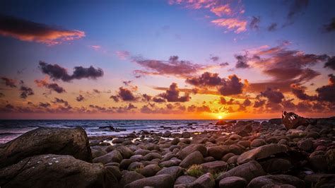 Last Sun Rays Above The Horizon Sea Coast Rocks With Rocks And Stones