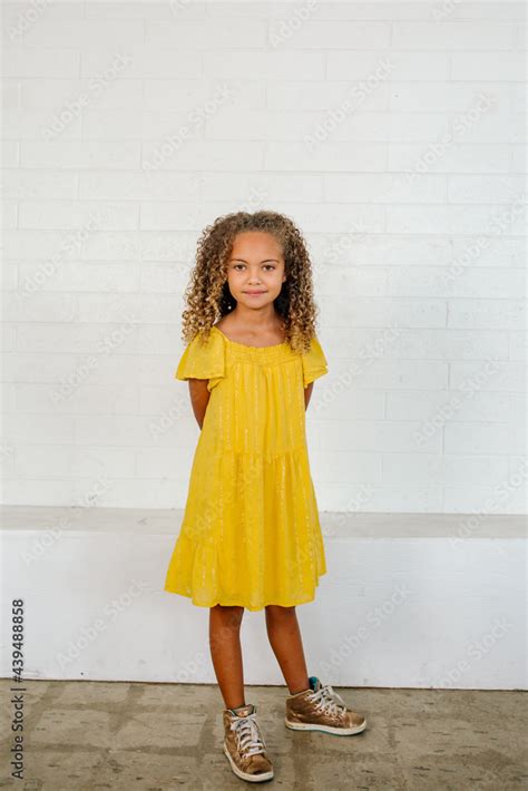Beautiful Young Bi Racial Girl Wearing Vivid Yellow Dress And High Top